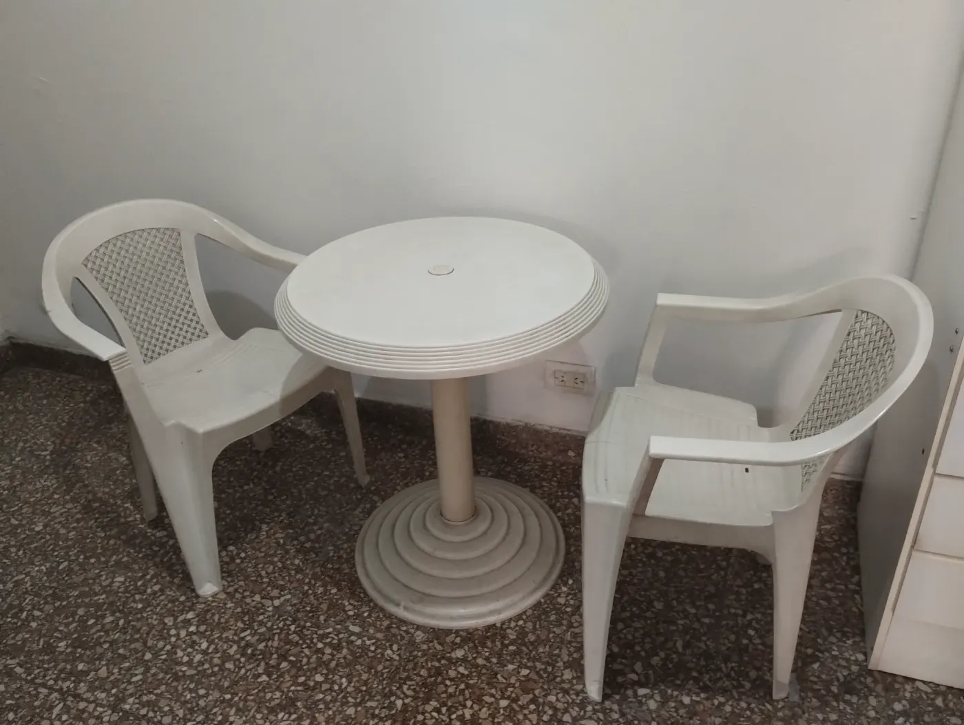 Mesa de jardín con dos sillas blancas