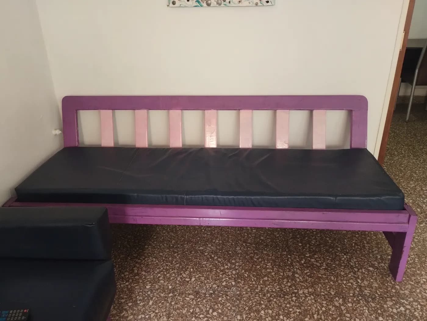Sillón de madera violeta y rosa con colchoneta de cuerina azul