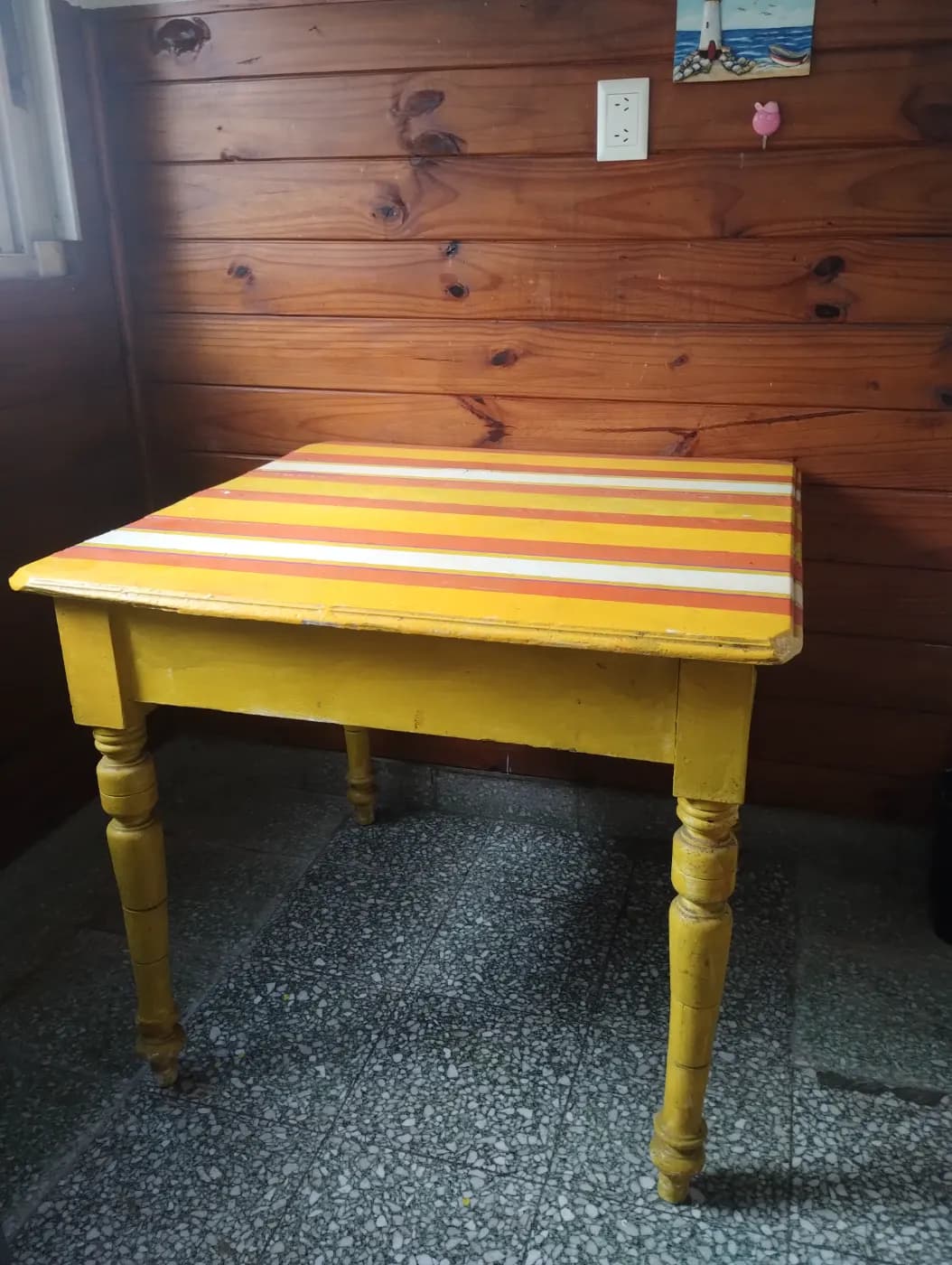 Mesa cuadrada de madera artesanal de color amarilla, naranja y blanca